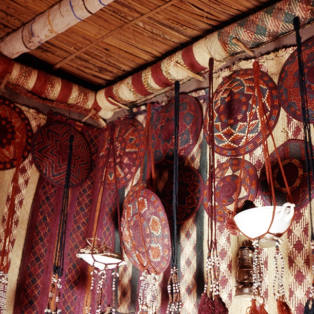 Mats, round baskets, and hanging slings in a bridal room, under the ceiling rolled up mats, stored on pegs. Mediig, W. Neja Sebue, 1963 (Photographed by the author).